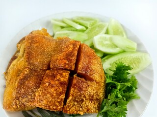 The crispy pork serve with fresh vegetable photo on the white background