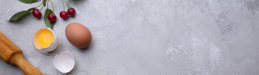 Ingredients for baking eggs rolling pin berries on a gray background. Cookie pie or cake recipe mockup. Preparing for culinary baking.