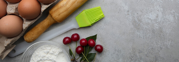 Ingredients for baking eggs rolling pin berries on a gray background. Cookie pie or cake recipe mockup. Preparing for culinary baking.