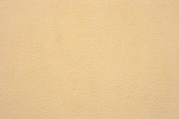 Beige wall, plaster of paris for a fur coat. Embossed porous wall surface. Decorative plaster for facade walls. Texture, background or backdrop.