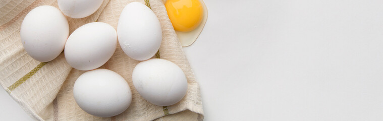 Lots of eggs and a broken egg on the tea towel.