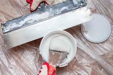 mixing, stirring gypsum putty with a spatula close-up