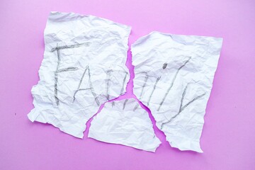 The text of the family on a white sheet of paper in a cage on a purple background. Destruction and divorce. Step by step. Family security.