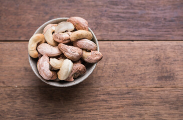 Cashews nuts with shells,homemade roasted process on wooden background