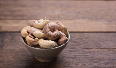 Cashews nuts with shells,homemade roasted process on wooden background