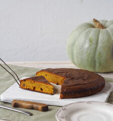 Homemade pumpkin pies.Rustic cooking style. Pumpkin muffin on a white rustic plate with a kitchen napkin and a large pumpkin in the background.