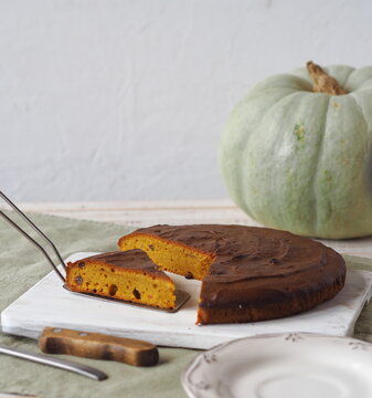 Homemade pumpkin pies.Rustic cooking style. Pumpkin muffin on a white rustic plate with a kitchen napkin and a large pumpkin in the background.