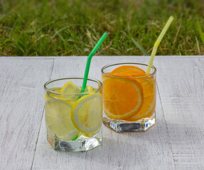 glasses with a refreshing drink of lemons and oranges