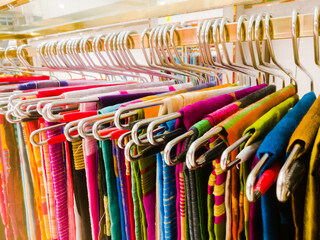 Sarees hanging on hangers in a textile showroom.
