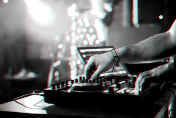 hands DJ mixing and playing music on a professional controller mixer