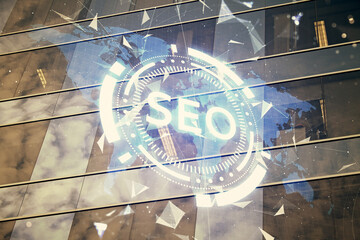 SEO hologram on city view with skyscrapers background double exposure. Search optimization concept.
