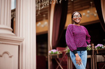 African American woman wear eyeglasses posing outdoor.