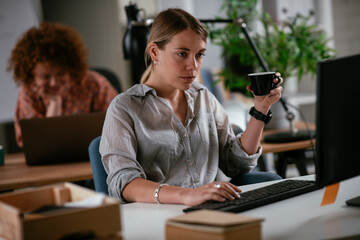 Young businesswoman drinking coffee in her office	
