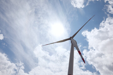 Modern wind turbine against cloudy sky, low angle view. Alternative energy source