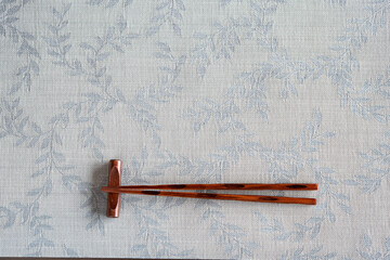 Traditional japanese chopsticks on chopstick rest on plate mat