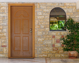 Fototapeta na wymiar contemporary house entrance with wooden door and potted small plant, Athens Greece