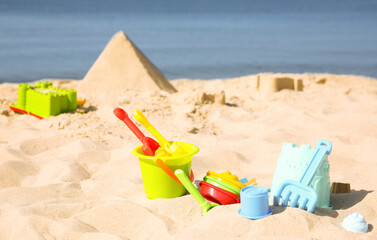 Different child plastic toys on sandy beach