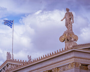 Fototapeta premium Apollo and Athena ancient greek gods with the blue white Greek flag and sky, Athens Greece