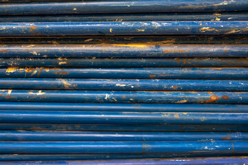 old ragged metal rusty blue building pipes in a heap. rough surface texture