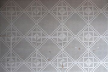 white paper plate with holes and square patterns. rough surface texture