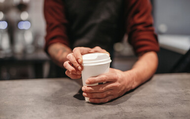 Bartender serving takeaway coffee in coffee shop