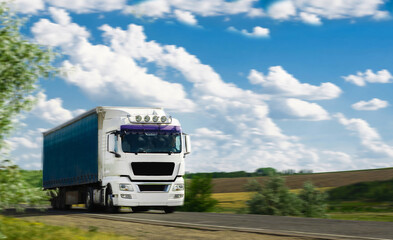 White Truck with container on highway and blue sky with  clouds. Cargo transportation concept. 