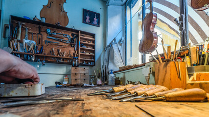 Luthier violin maker Carlos Roberts working in his workshop in Cremona, Italy