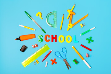 school supplies and the word school from multicolored letters on a blue background. Back to school concept. school learning and education concept. Stationery store concept. flat lay, top view.