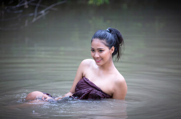 young Asian woman bathing in the river