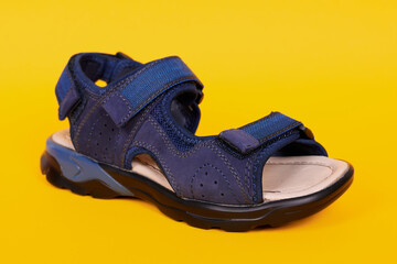 Kids orthopedic leather sandal, child shoes. Isolated on yellow background.
