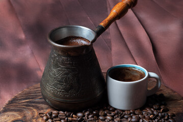 Coffee in cezve and white cup on a red background