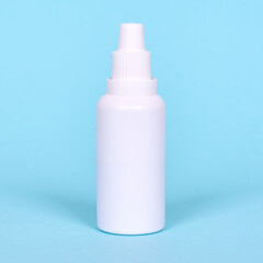 Nasal spray, drops in white bottle. Isolated on blue background.