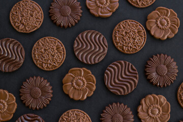 Milky and bitter round shape chocolate Madlen,designed on black background,flat layout.