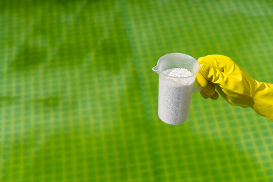 addition of chlorine powder for the pool to remove algae and disinfect water. inflatable swimming pool care concept.