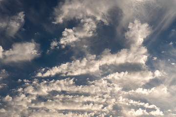 White clouds all over the sky with a blue background of daylight sky. Natural composition of the sky. Design element, background.