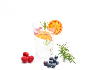 Gin and tonic with orange, rosemary, blueberries and raspberries