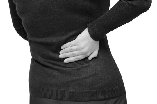 The woman has a pain in her lower back. Horizontal, black and white isolated photo, medical concept