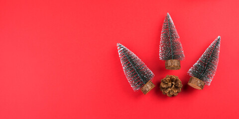 Christmas new year red festive minimal background with toy xmas trees and pine cone. Copy space