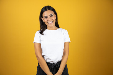 Obraz premium Young beautiful woman standing over yellow isolated background smiling with her arms crossed