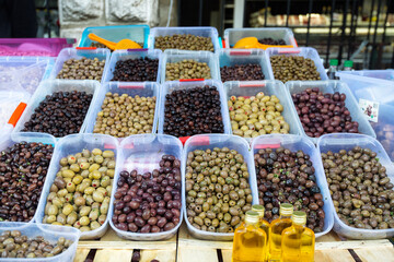Bowls of various olives for sale at an open street market. Different kinds of mediterian olives on a counter. Street food market.