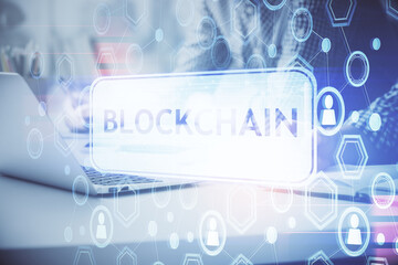 Blockchain theme hologram with man working on computer on background. Concept of crypto chain....