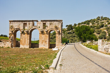 Fototapeta na wymiar Ruins of city gate near the road to arheological site of ancient Lycian city of Patara, Lycia, Turkey
