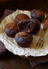 Chocolate banana muffin sprinkled with cocoa on dark background, vertical