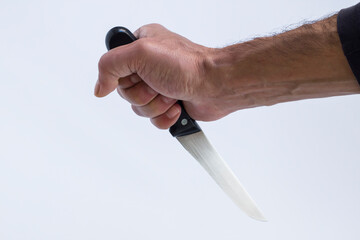 Hand of adult male holding a sharp knife on white background,close up.