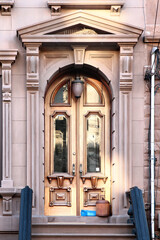 Wooden vintage entry door decorated with arch and corbels. New York. USA. © alexzosimov