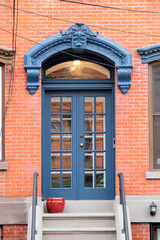 Blue vintage entry door in New York decorated with arch and corbels. USA.