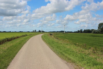 Fototapeta na wymiar Rural landscape with windmills and country road in the Netherlands. Photo was taken on a beautiful sunny day with and clear blue sky.