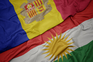waving colorful flag of kurdistan and national flag of andorra.