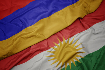 waving colorful flag of kurdistan and national flag of armenia.