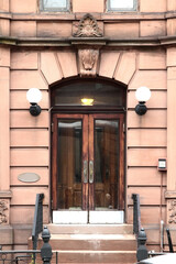 Brown wooden vintage arched entry door decorated with keystone and rustication. New York. USA.